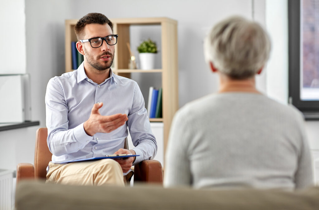 geriatric psychology, mental therapy and old age concept - psychologist talking to senior woman patient at psychotherapy session